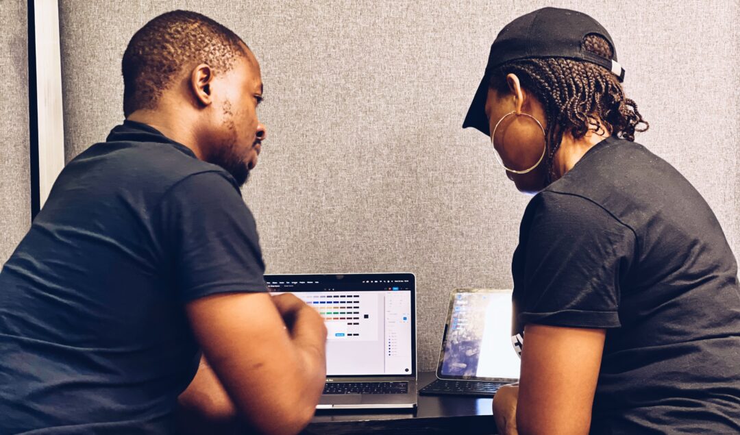 Two black people facing their computers
