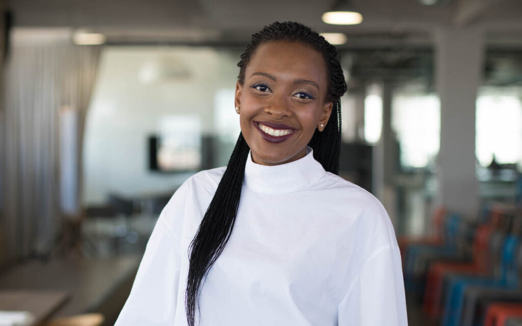 Lethabo Motsoaledi a Black woman with long black braids wearing a white top, smiling at the camera