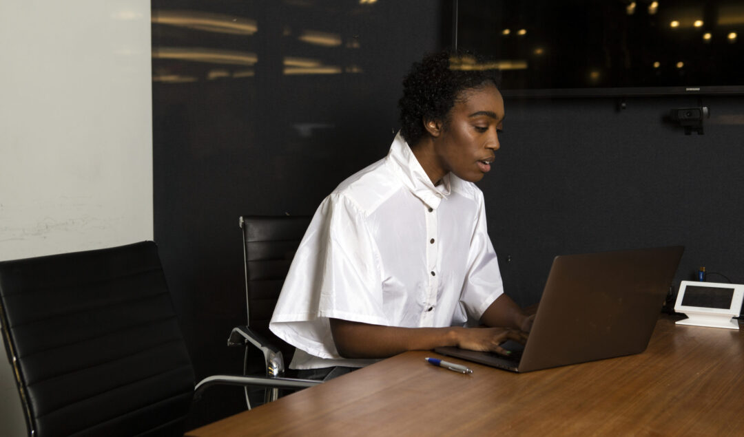 Black woman typing at laptop
